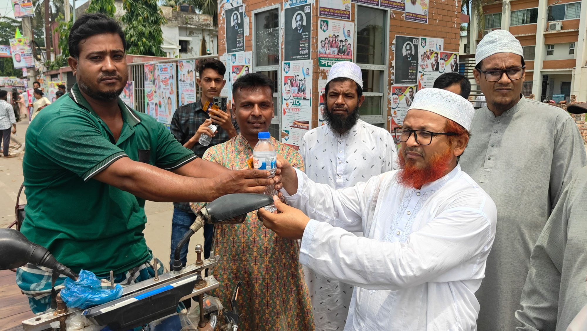কোটালীপাড়ায় পথচারী ও ভ্যান চালকদের মাঝে পানি এবং খাবার স্যালাইন বিতরণ